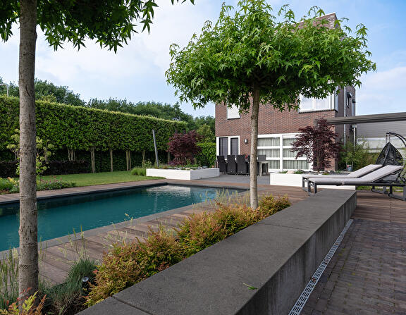 Tuin met poolhouse, zwembad en bomen tegen inkijk vanaf de zijkanten