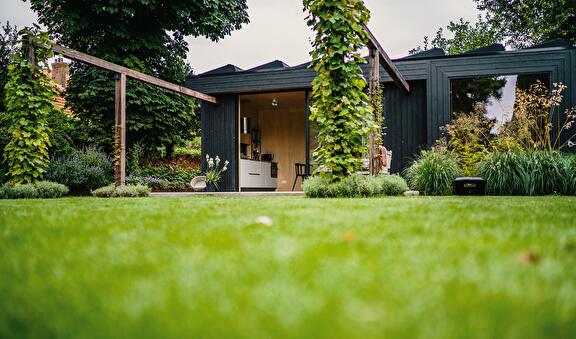 Grote stadstuin met pergola en tuinhuis in Assen