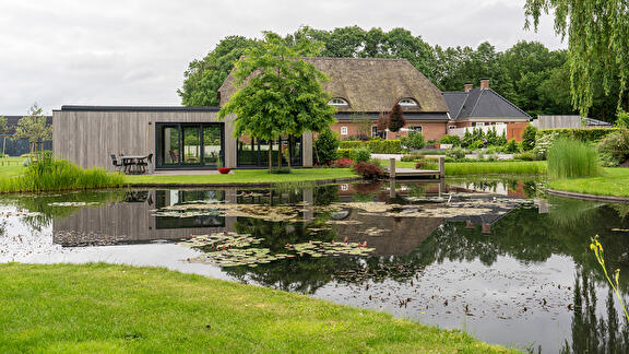 Landelijke villatuin met grote vijver, poolhouse en natuurzwembad